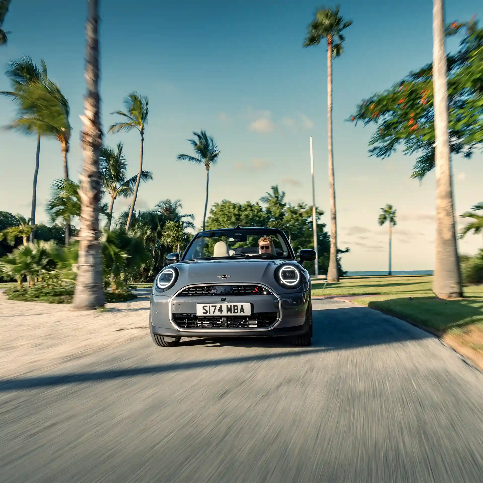 Front view of a driving MINI Cooper Convertible in Copper Grey on street